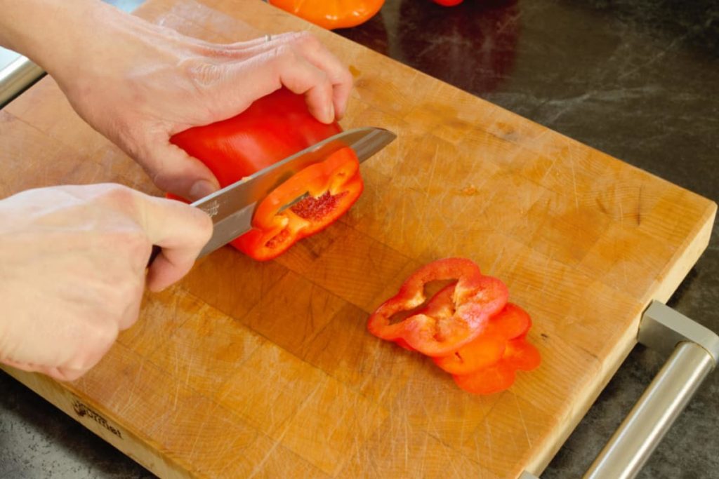 slicing bell pepper rings off a hollowed out pepper