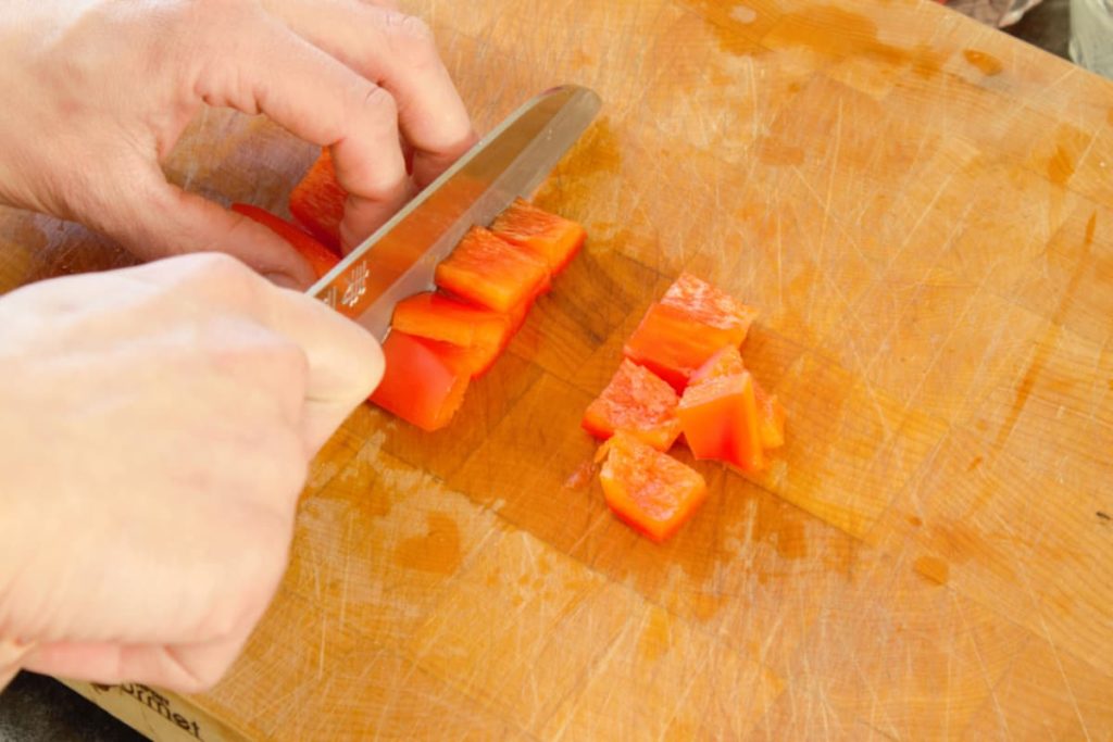 close up of sliced bell pepper rings on a wooden cutting board