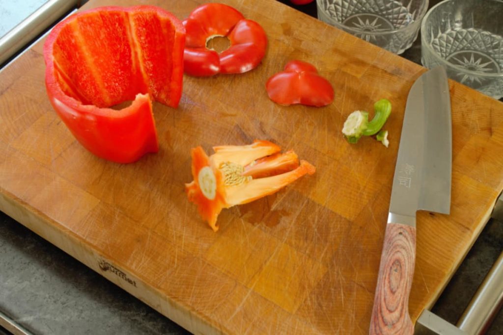 a fully cored bell pepper displayed on a wooden cutting board