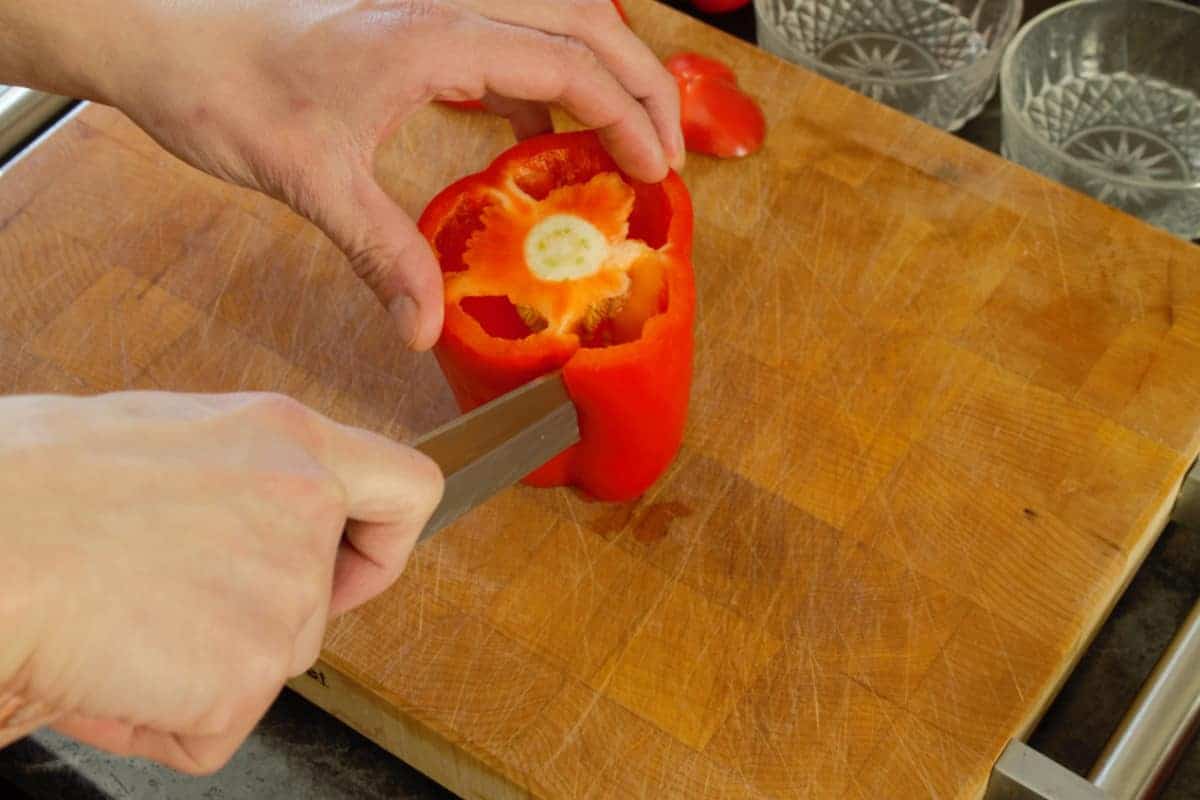 a fully cored bell pepper displayed on a wooden cutting board