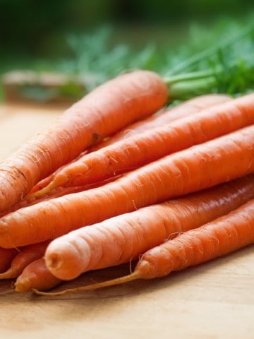 fresh carrots on a wooden cutting board