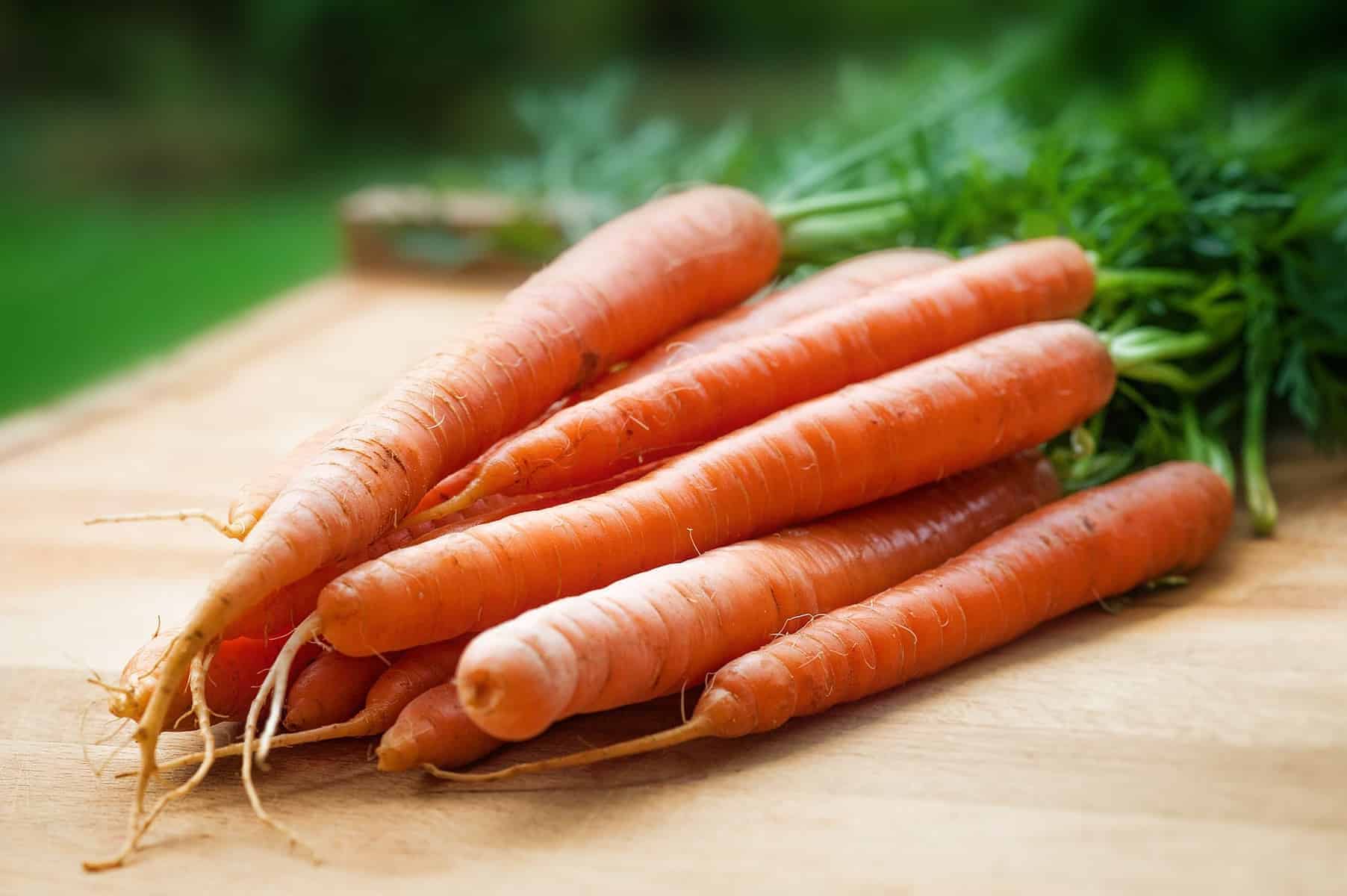 fresh carrots on a wooden cutting board