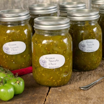 canadian green tomato chow chow in labeled mason jars on a rustic wooden surface