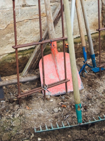 horizontal image of various gardening tools that need to be cleaned