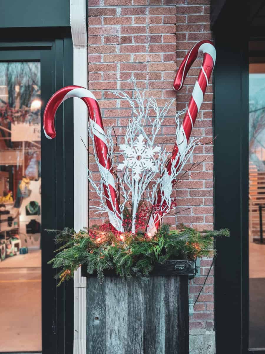 a christmas themed planter display in front of a brick wall