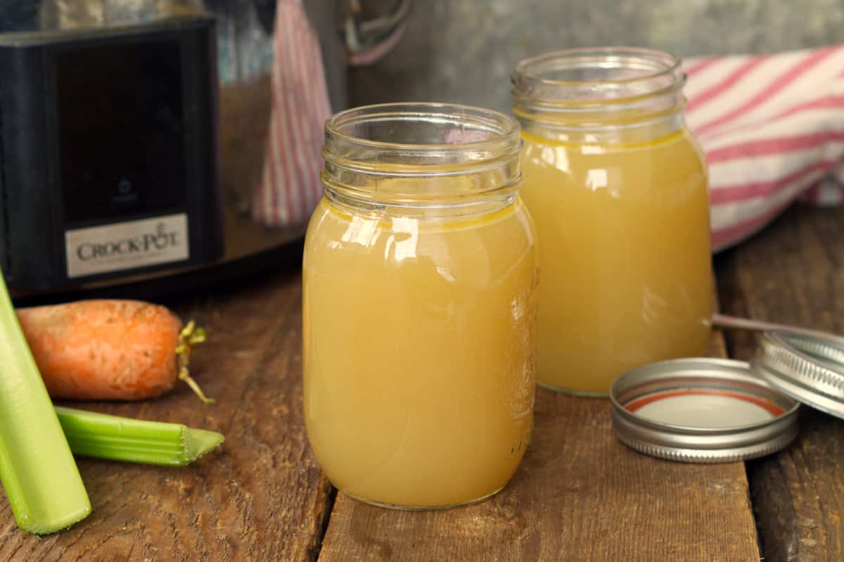 slow cooker turkey stock cooled and displayed in two mason jars