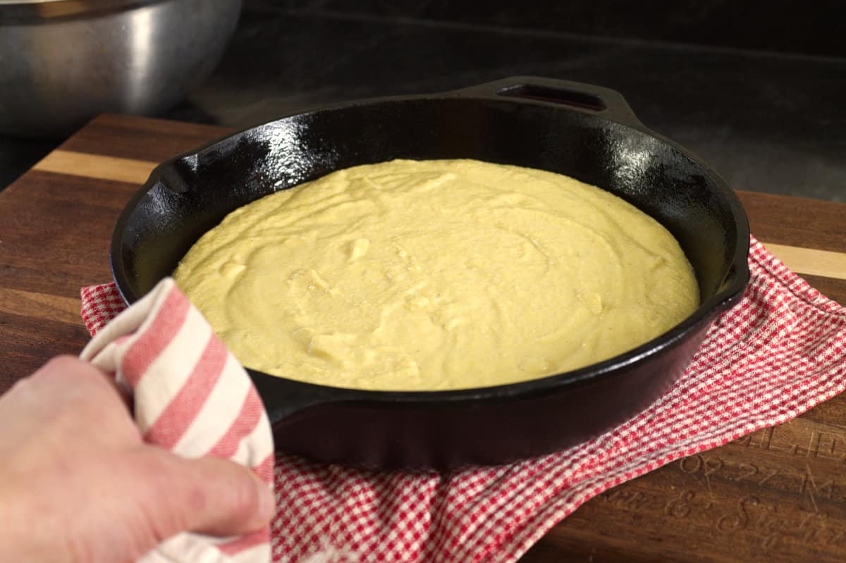cornbread batter added to the hot cast iron skillet