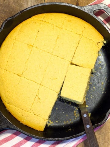 dairy free cornbread cut into portions in a cast iron skillet