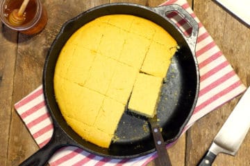 top down shot of golden brown dairy free cornbread in a cast iron skillet