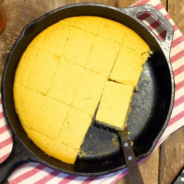 top down shot of golden brown dairy free cornbread in a cast iron skillet