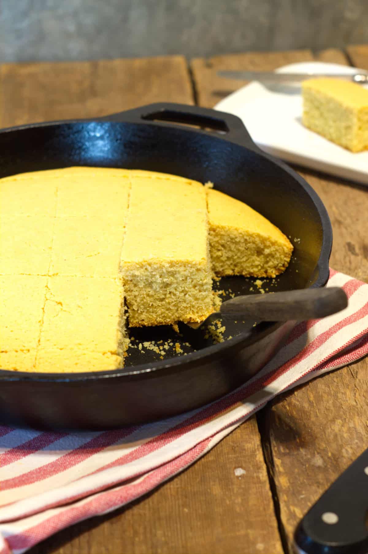 golden brown dairy free corn bread cut into rectangles in a cast iron skillet