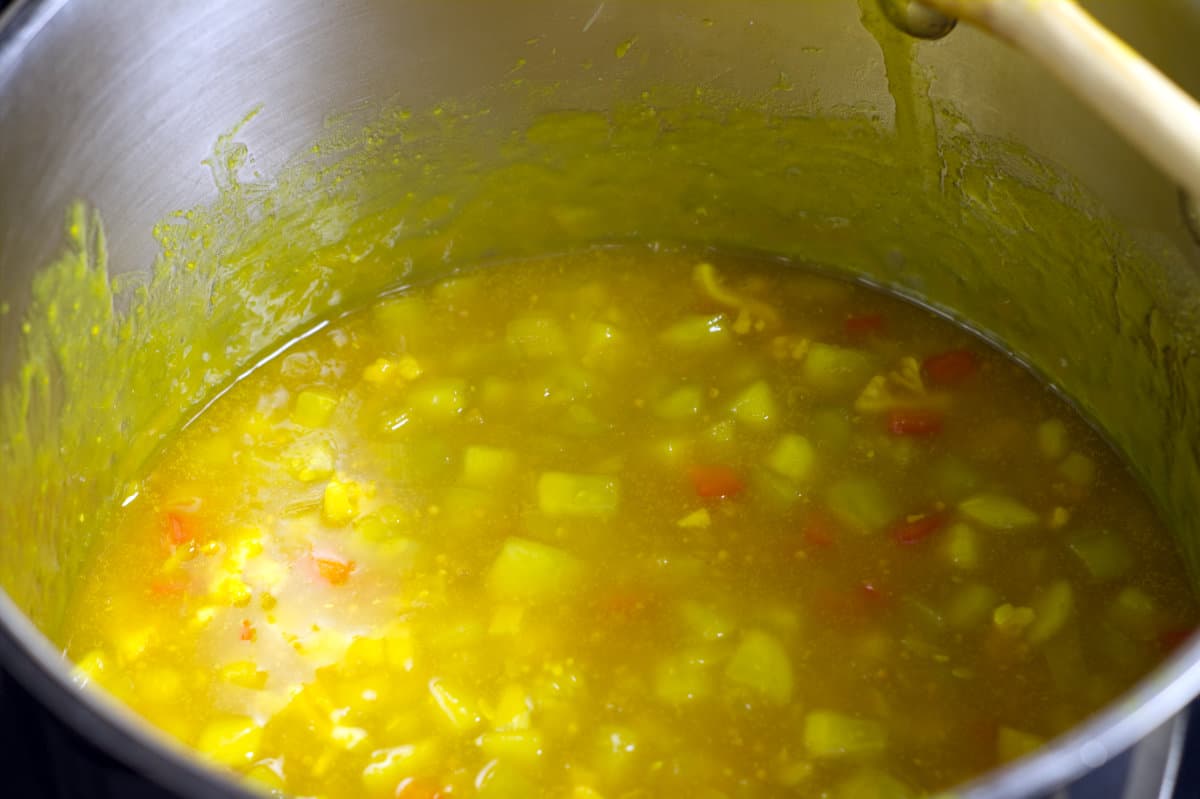 Mustard pickles cooking in a stainless steel pot.