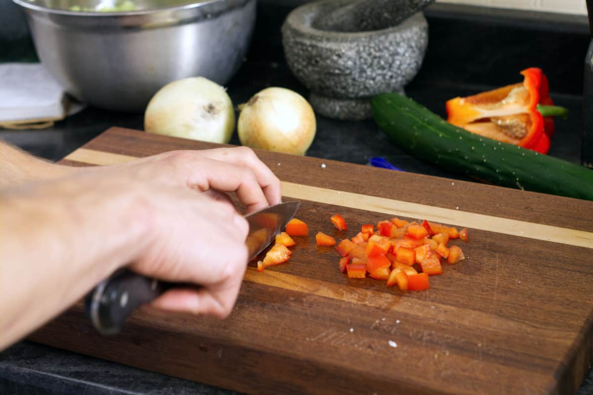 Cutting red bell pepper into a small dice cut.