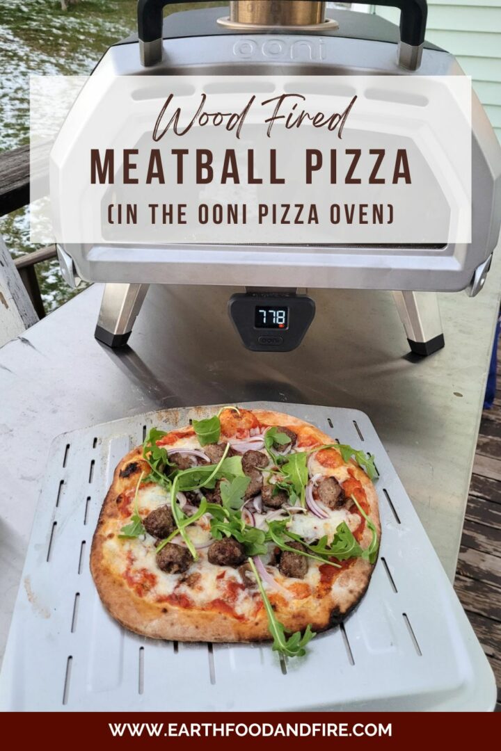 wood fired meatball pizza on a steel pizza peel in front of an ooni oven. The image is overlaid with a pinterest title banner.