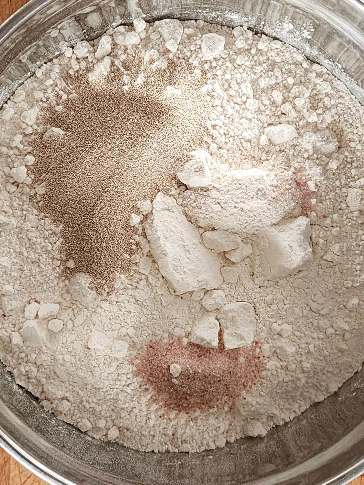 Homemade pizza dough ingredients - flour, salt, yeast and sugar - placed in the bowl