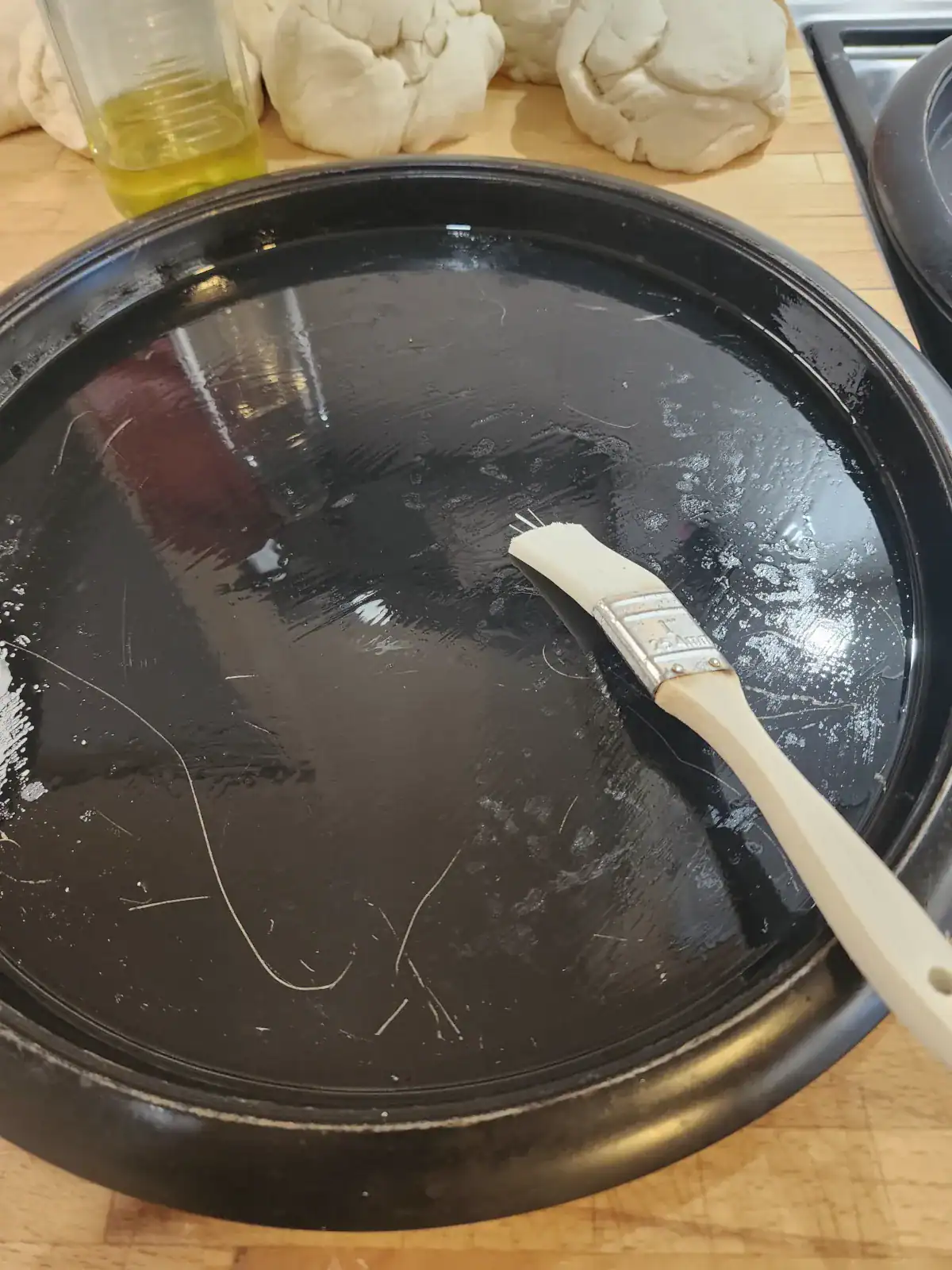 Oiled pizza tray for homemade pizza dough