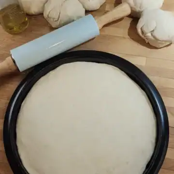 Homemade pizza dough on rolled and ready on pizza tray