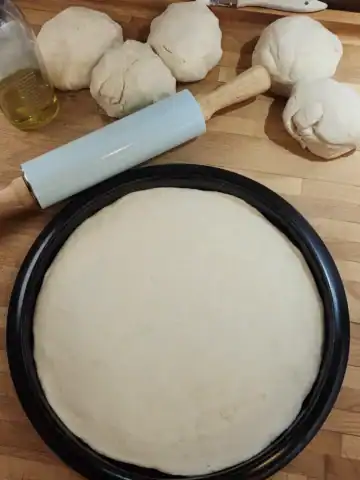 Homemade pizza dough on rolled and ready on pizza tray