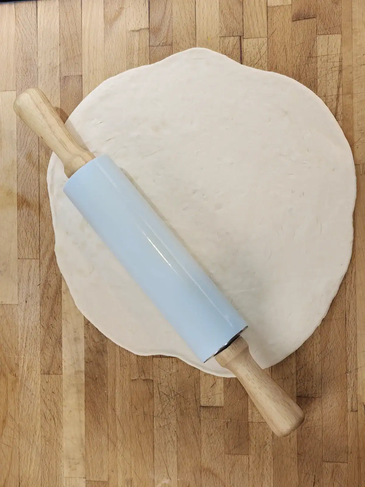 Homemade pizza dough with rolling pin