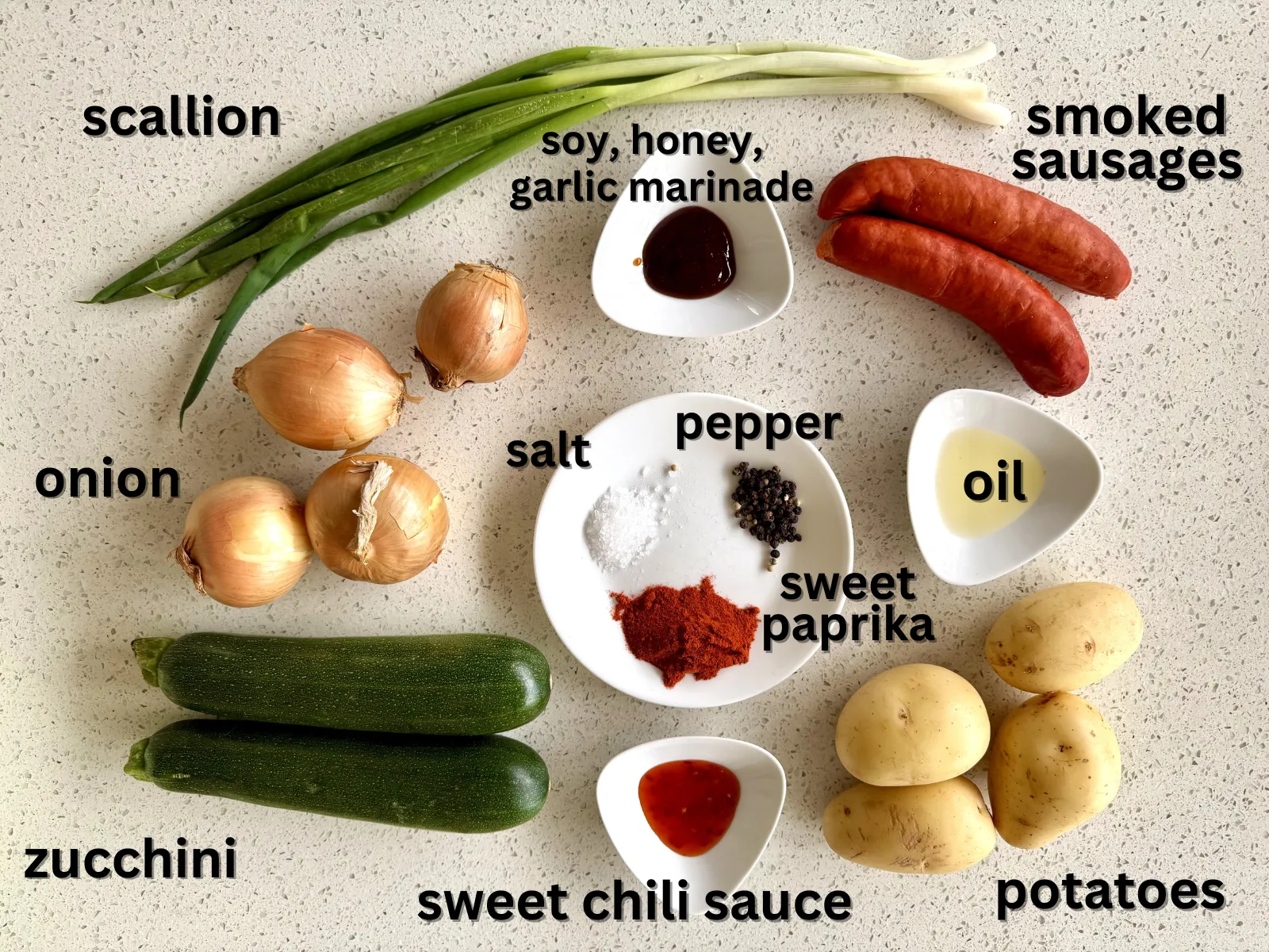 All ingredients for the potato goulash with sausage laid on the table with descriptions