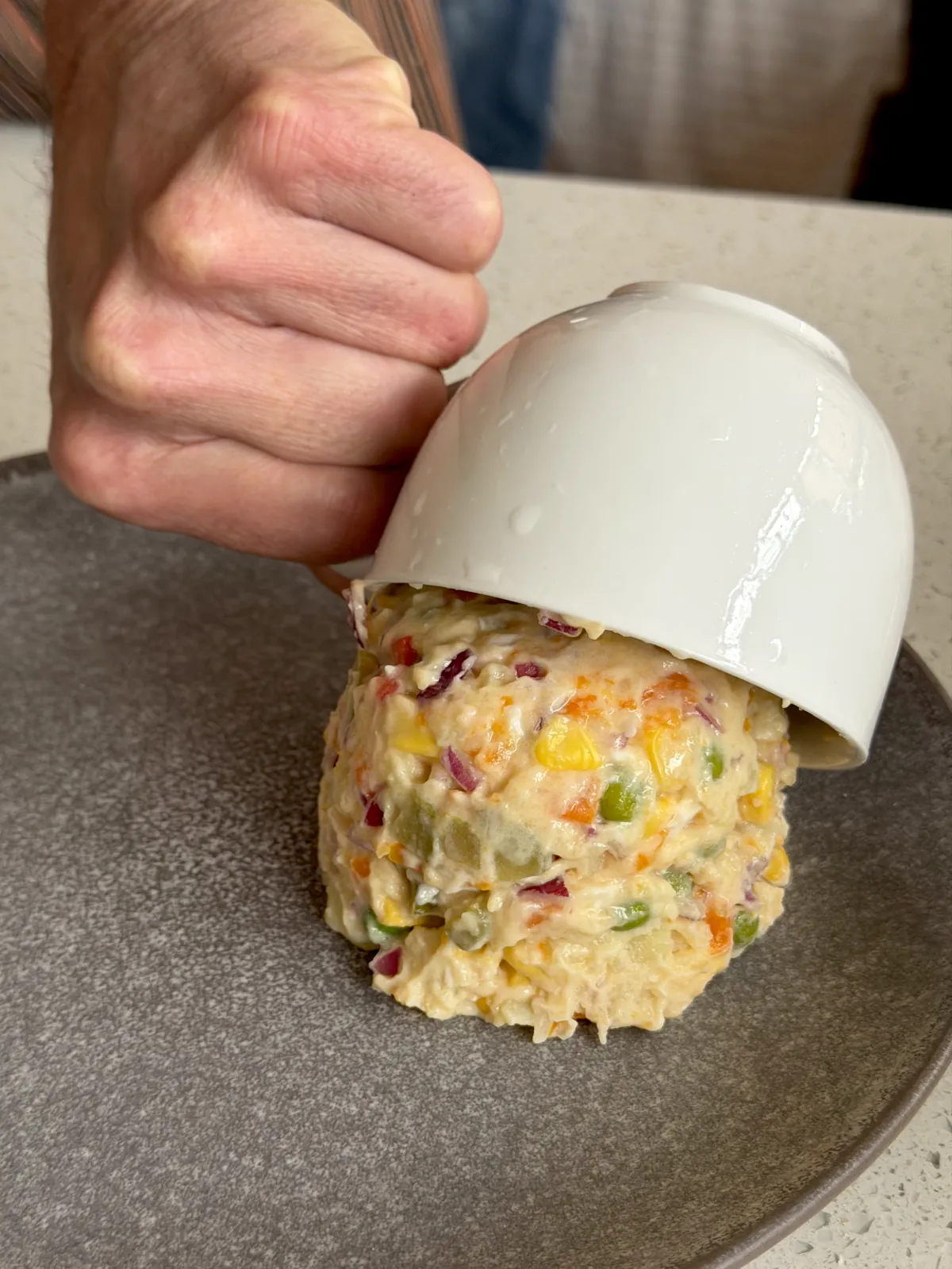 Tiping out the potato salad dome onto a plate