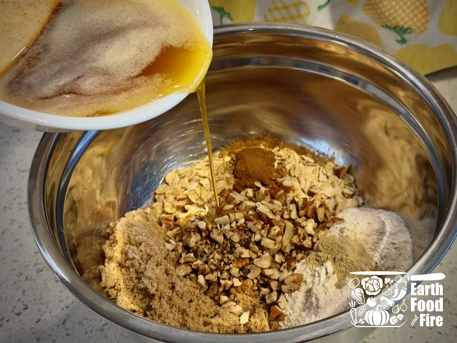 Browned butter being poured into the bowl with applesauce crisp topping ingredients