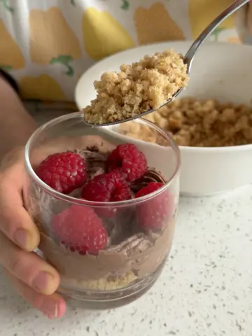 Adding layers - cake crumbles on top of filling and raspberries