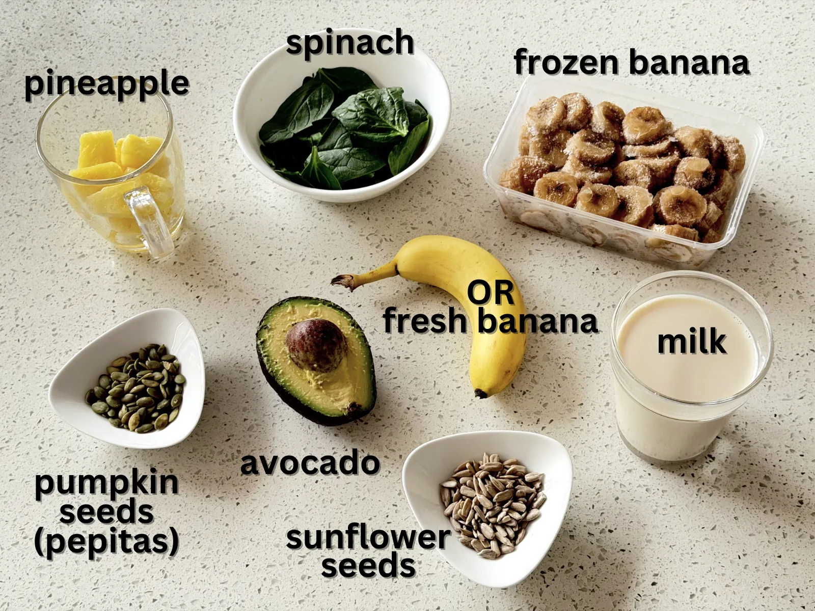 Avocado smoothie ingredients: avocado, spinach, banana, pineapple, milk, pumpkin and sunflower seeds