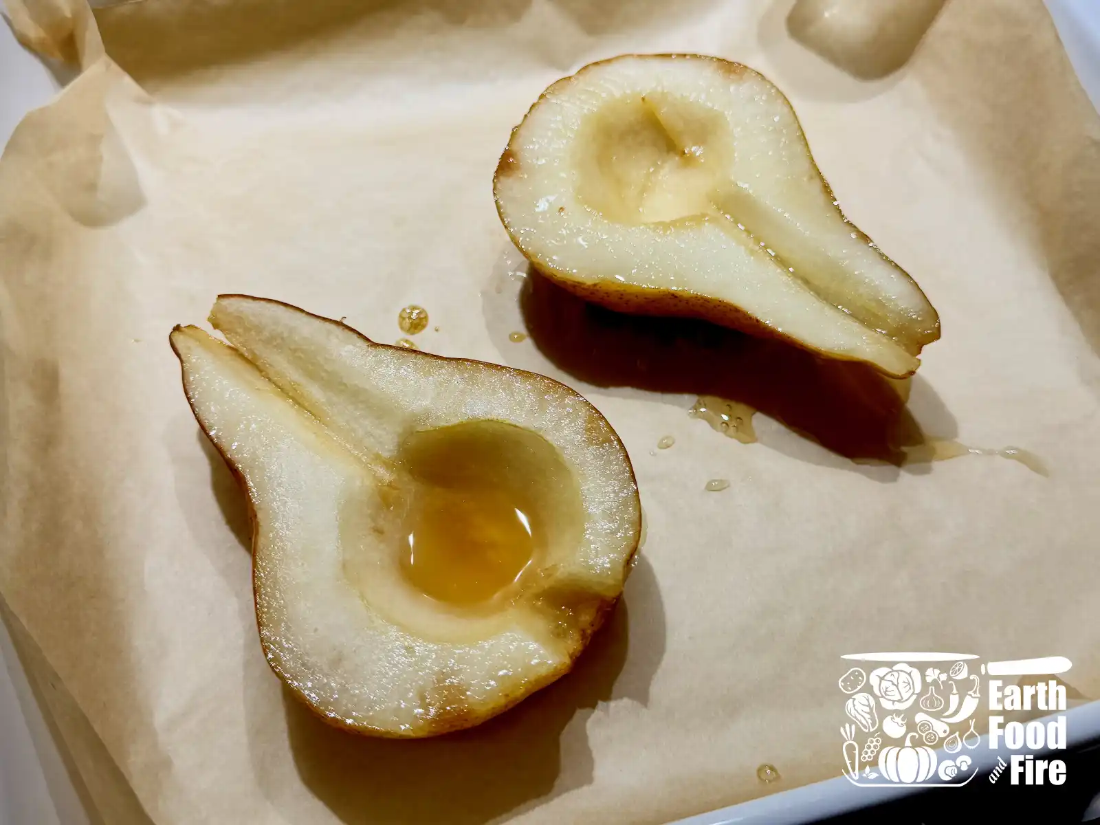 Two halves of a pear on a baking tray