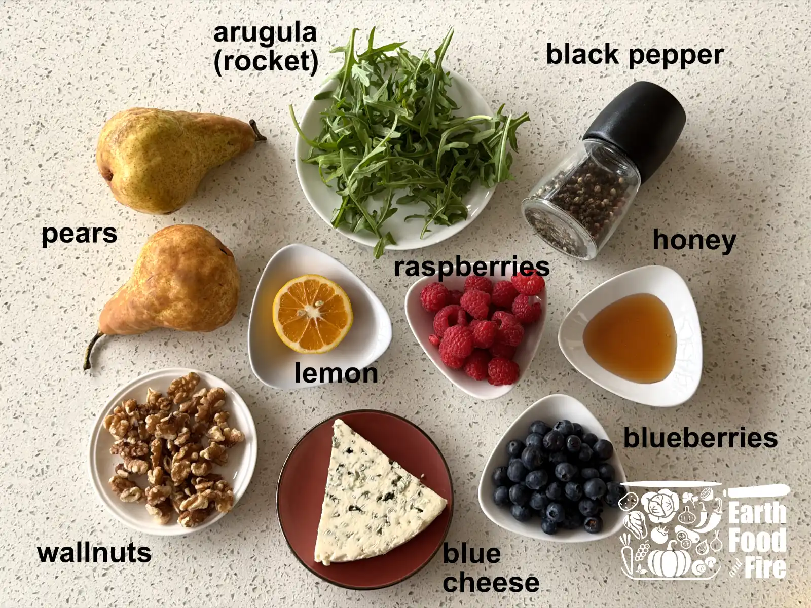 Ingredients for baked pears with blue cheese: halved pears, honey, Danish blue cheese, walnuts, blueberries, raspberries, arugula and fresh thyme, arugula, lemon