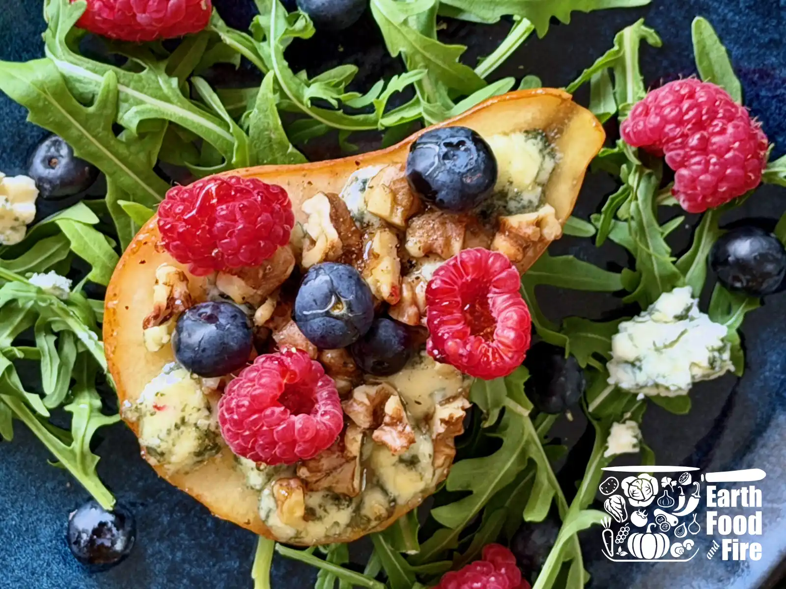 Baked pears with melted blue cheese, toasted walnuts, fresh blueberries and raspberries on a bed of arugula, drizzled with honey