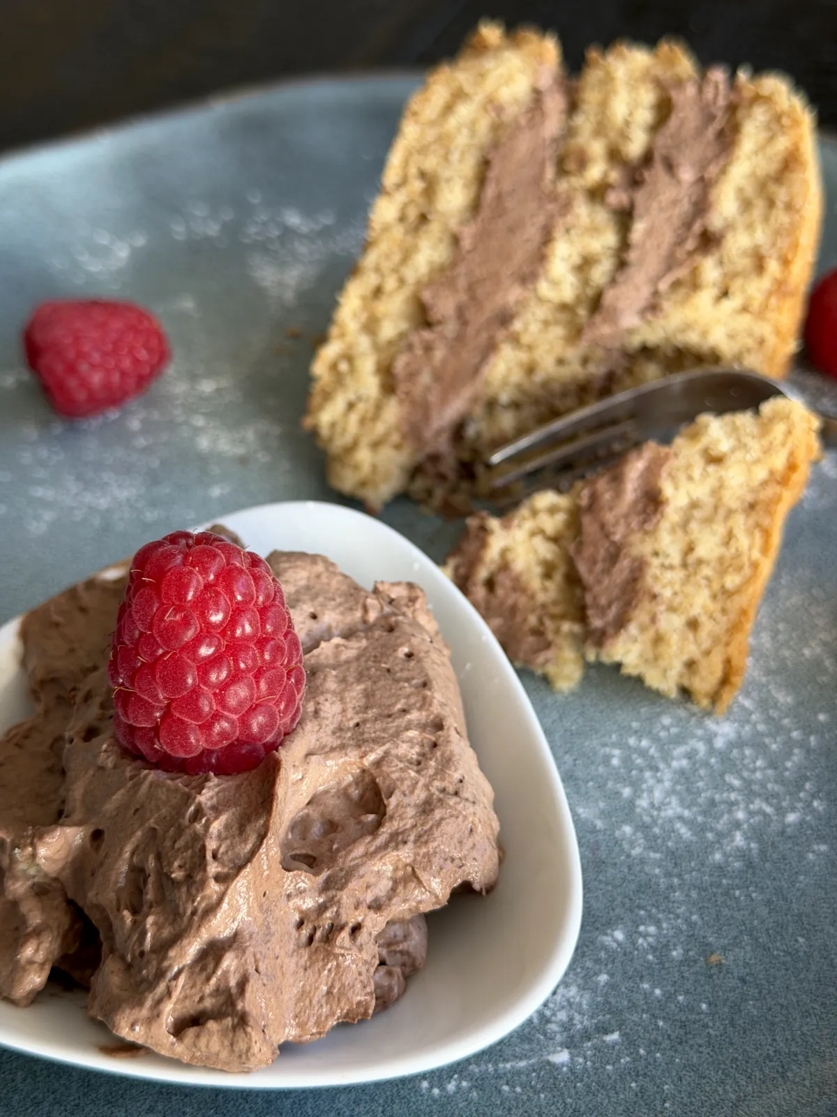 The Rich Chocolate Mascarpone cake Filling in the bowl and on the cake with rasberries