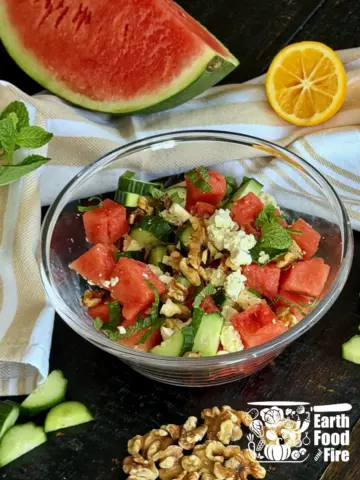 Feta cheese and watermelon salad recipe served in a glass bowl with fresh mint and toasted walnuts