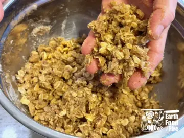 Hand holding the crumbed mixed applesauce crisp topping ingredients