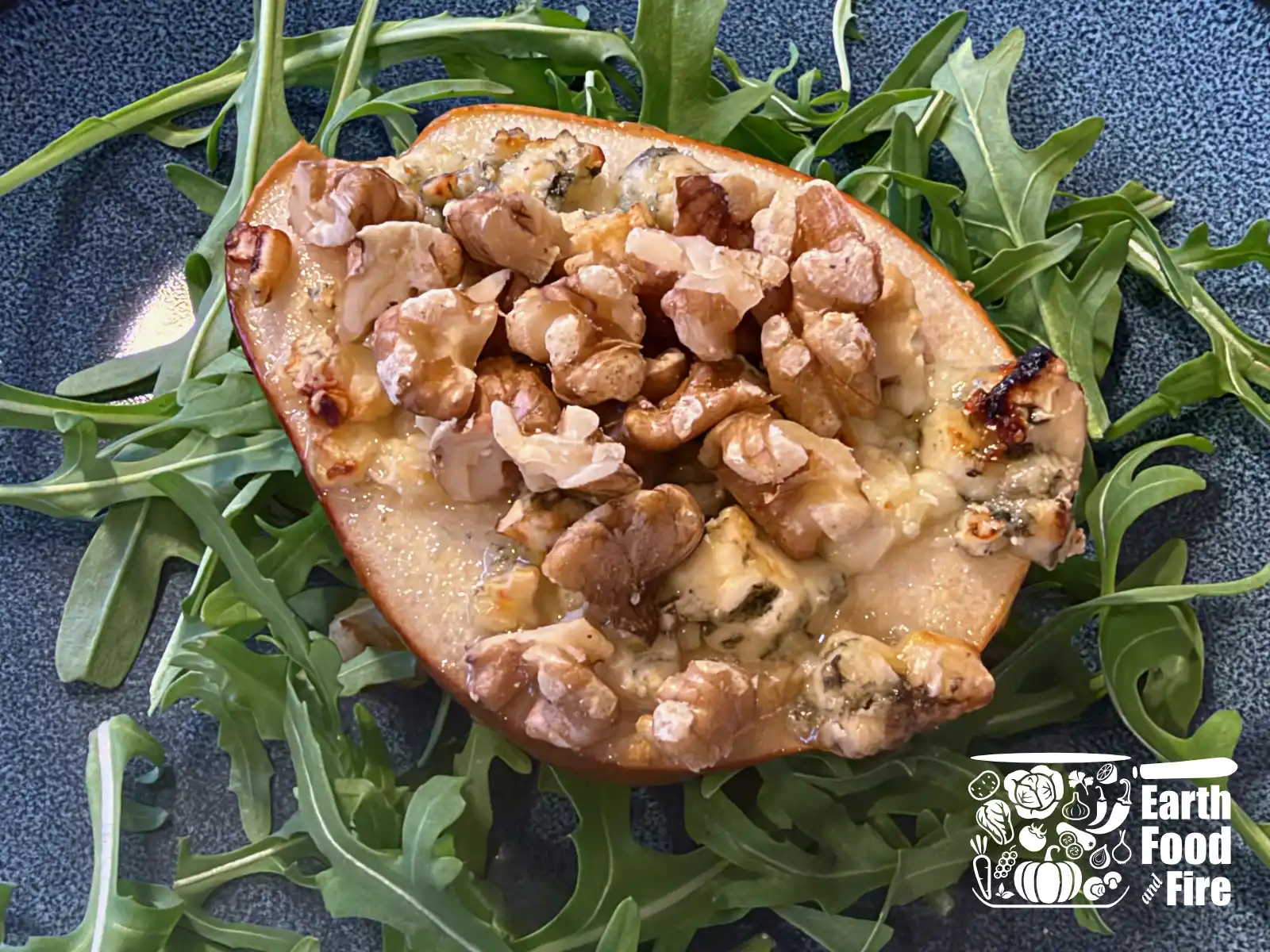 Pear with melted blue cheese and walnuts served on bed of argula