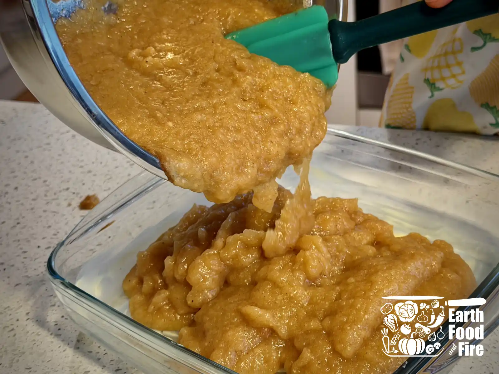 Mixed applesauce crisp filling being poured from the mixing bowl into the baking tray.