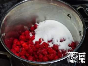 Raspberries and sugar in the stainless steel pot, ready for cooking