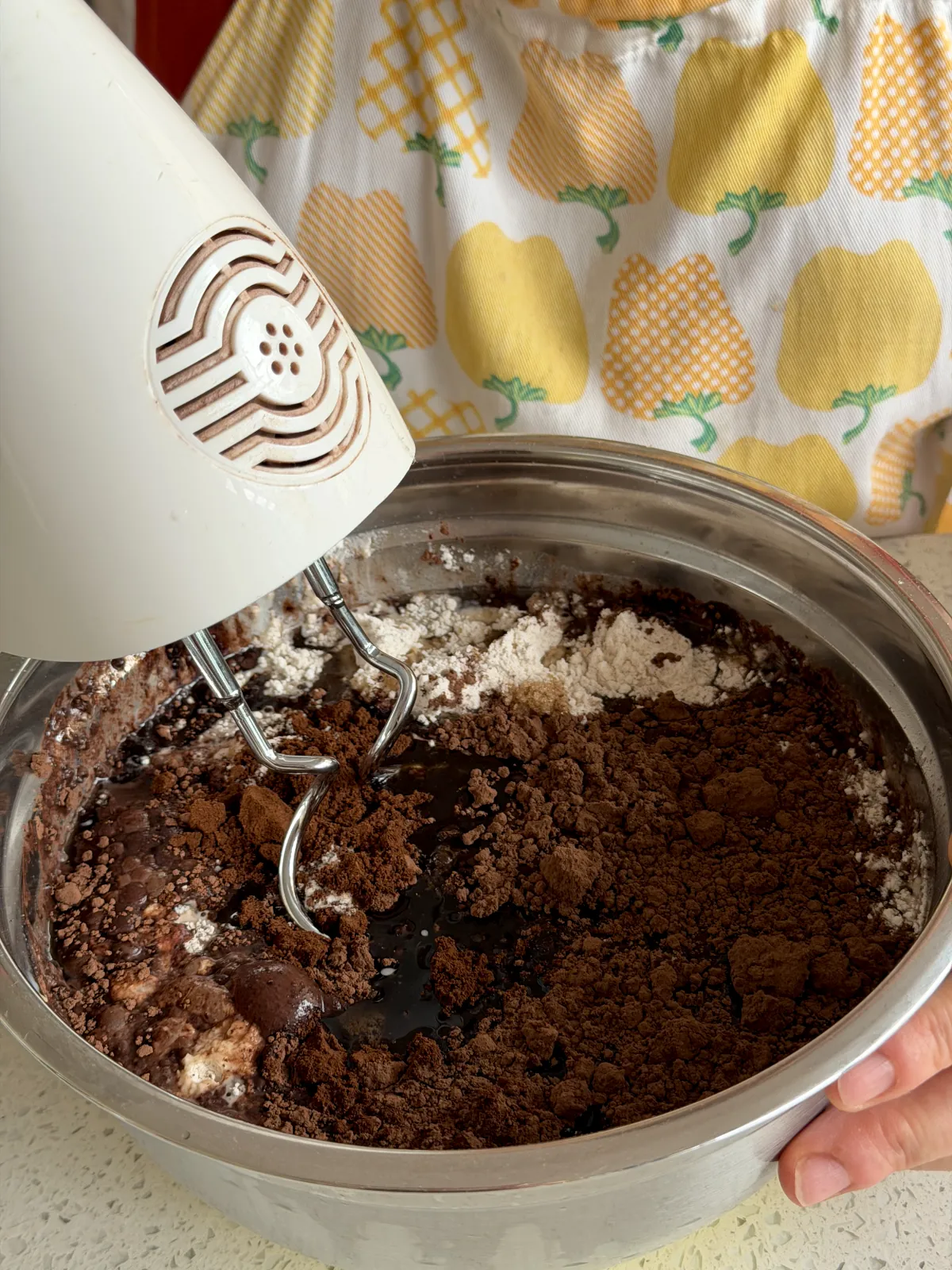Mixing ingredients for a chocolate cake with a hand mixer using easy recipes for cakes