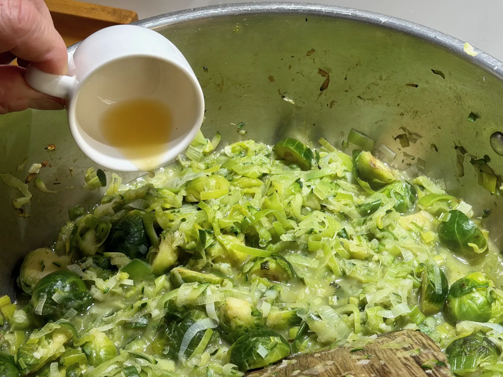 Adding lemon juice to sauteed Brussels sprouts mix.