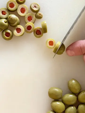 Slicing pimiento-stuffed olives