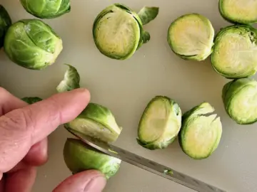Cutting sprouts in half for sautéed Brussels sprouts recipe