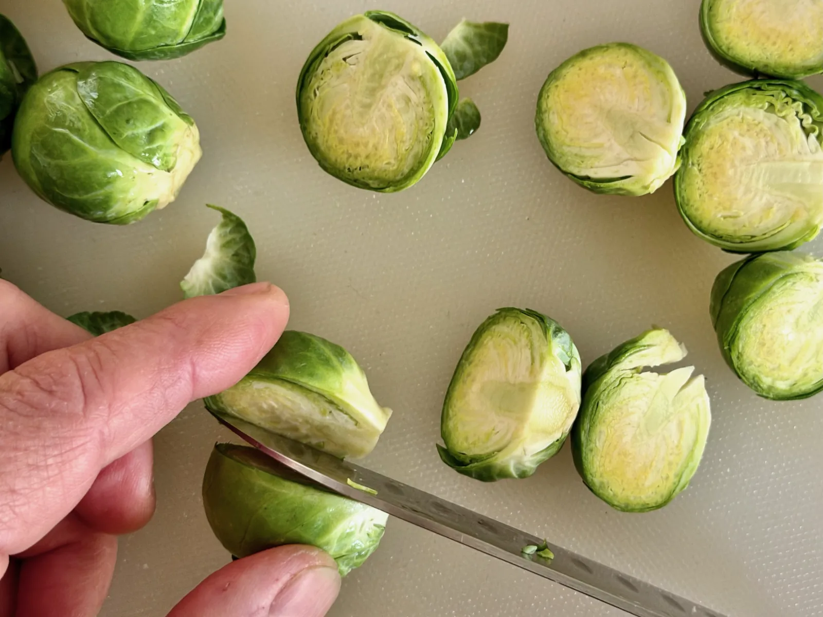 Cutting sprouts in half for sautéed Brussels sprouts recipe