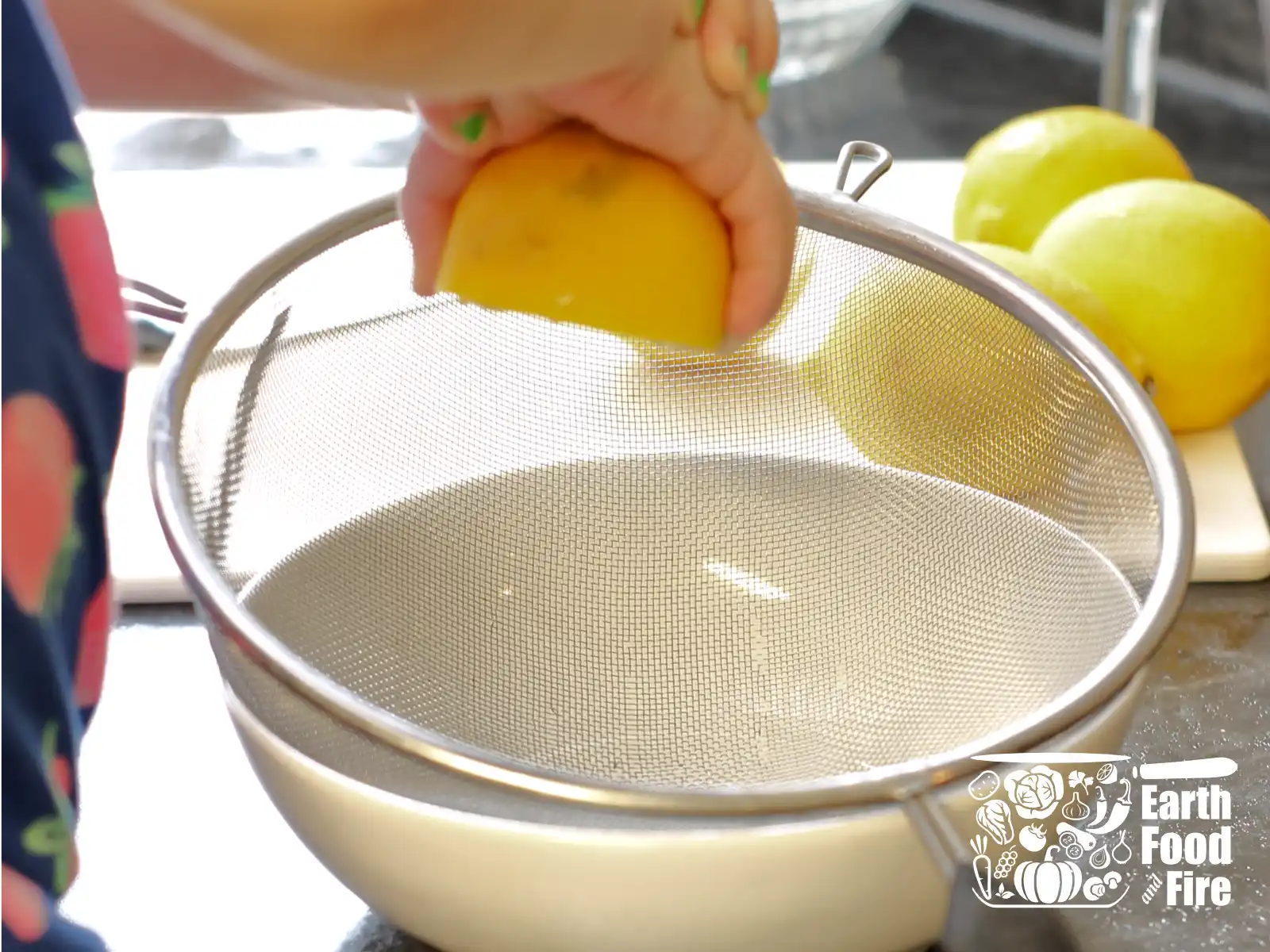 Squeezing lemon over a sieve and bowl