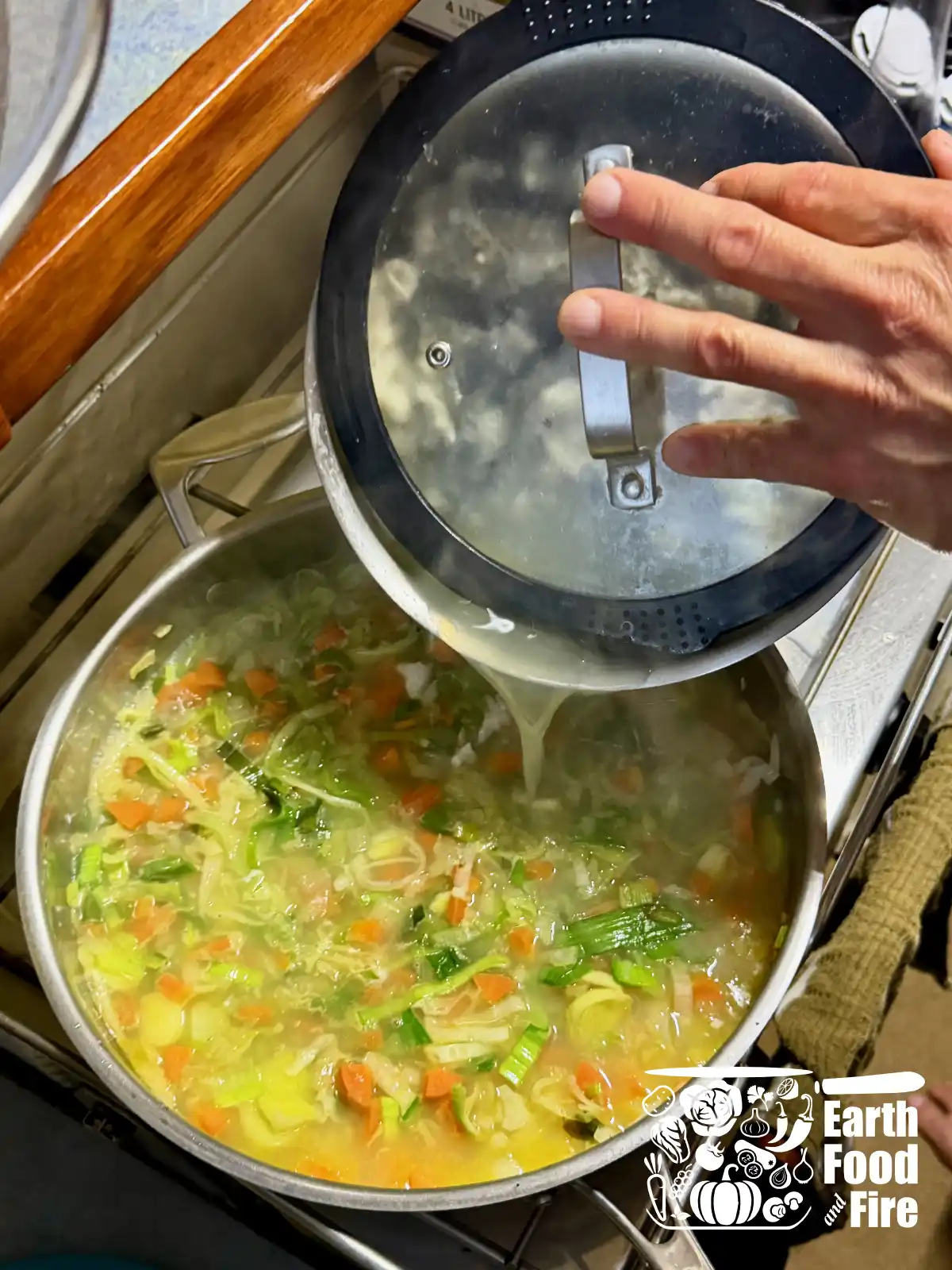 Straining fish stock into vegetables