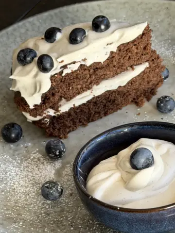Vanilla Crème Fraîche cake Filling and frosting in the bowl and on the cake with blueberries
